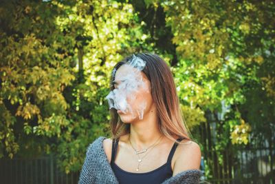 Portrait of young woman against plants