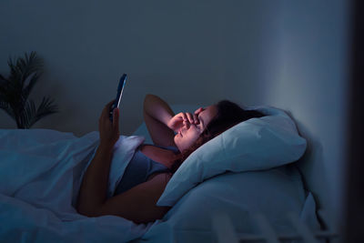 Young woman lying on bed at home