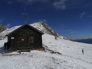 House on snow covered mountain against sky