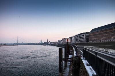 Of suspension bridge over river by city during sunset