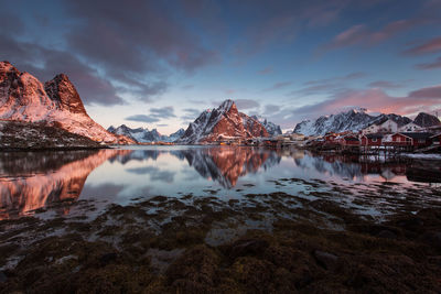 Scenic view of lake and mountains against sky during sunset