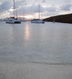 Sailboats sailing on sea against sky