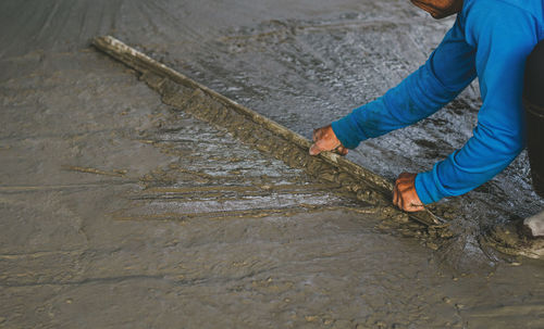 Low section of man holding wet shore