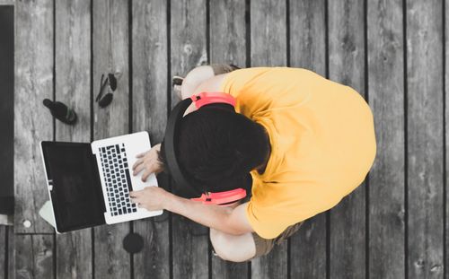 High angle view of woman using smart phone on wood