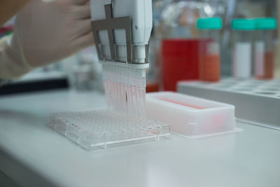 Cropped hand testing chemicals in laboratory