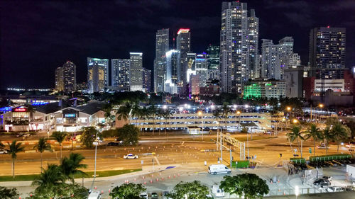 Illuminated buildings in city against sky at night