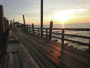 Pier over sea against sky during sunset