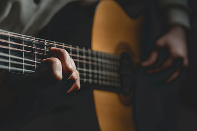 Midsection of man playing guitar