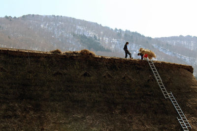 People on mountain road against sky