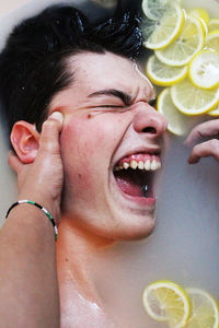 Directly above portrait of man with lemon slices in bathtub