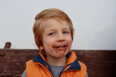 Portrait of a cute blond boy with chocolate on his face. comic five year old boy