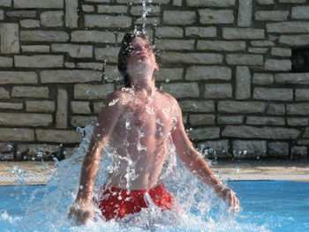 Full length of shirtless man in swimming pool