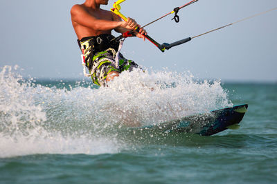 Man wakeboarding in sea against sky