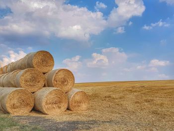 Hay bales on field against sky