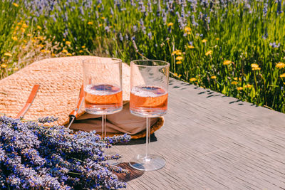 Two glasses with rose wine, bouquet of lavender flowers and straw bag. summer picnic
