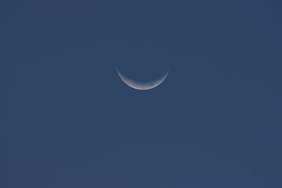 Low angle view of moon against blue sky