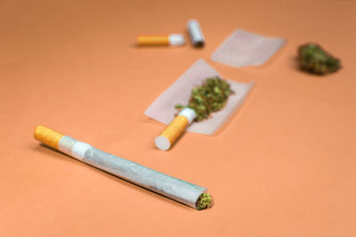 Close up of marijuana joint and materials to roll on blur background.