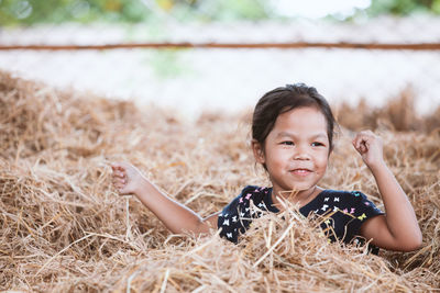 Smiling girl sitting on hay 