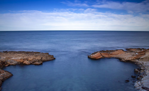 Rocks in sea against sky