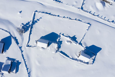 Snow covered remote village, homestead in the mountains. aerial drone view