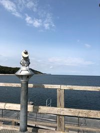 Railing by sea against sky