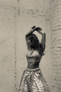 Rear view of woman standing against wall