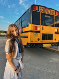 Portrait of smiling young woman standing in bus