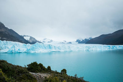 Glacier against cloudy sky