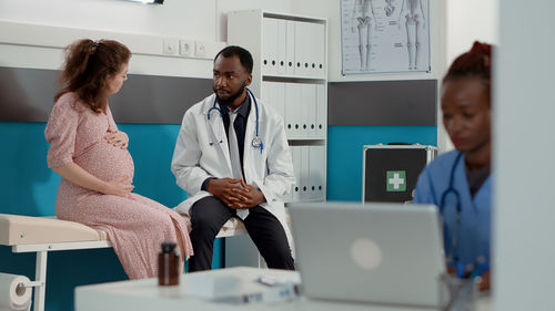 Doctor talking with pregnant woman in clinic