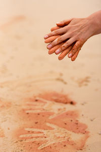 Cropped hands over sand at beach