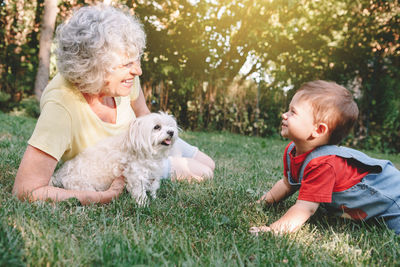 Baby boy and woman with dogs on field