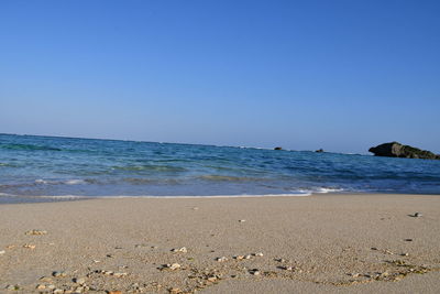 Scenic view of beach against clear blue sky