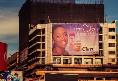 Portrait of smiling young woman against building in city