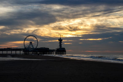 Ferris wheel at beach during sunset