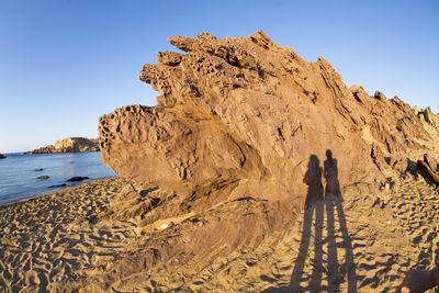 People on beach against clear sky