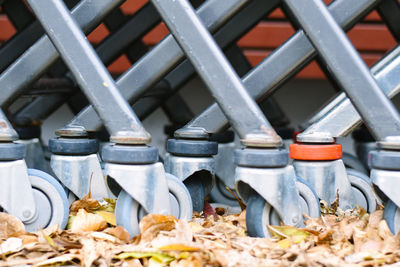 Close-up of shopping cart by leaves during autumn