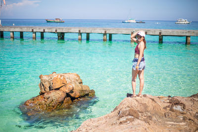 Portrait of woman standing on rocky shore