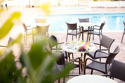 Empty chairs and table at sidewalk caf