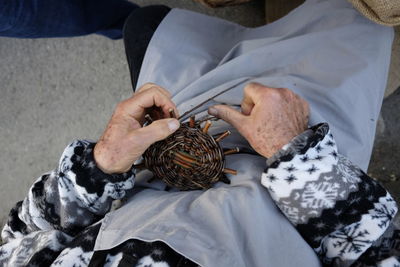 Midsection of male worker preparing wicker basket