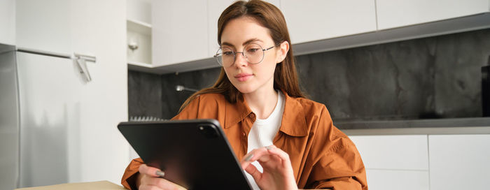 Young woman using digital tablet at home