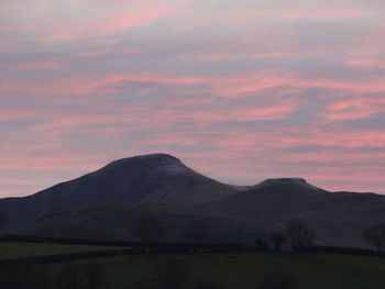 Scenic view of mountain against cloudy sky during sunset