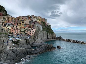 Buildings by sea against sky