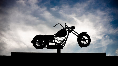Low angle view of silhouette bicycle against sky