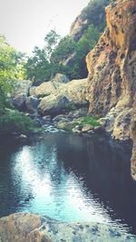 Scenic view of river by mountains against sky