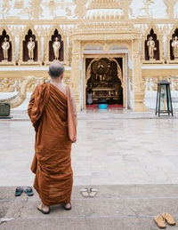 Rear view of man standing outside temple