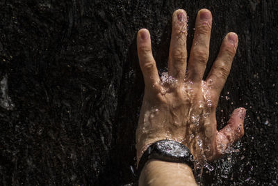 Close-up of wet hand in water