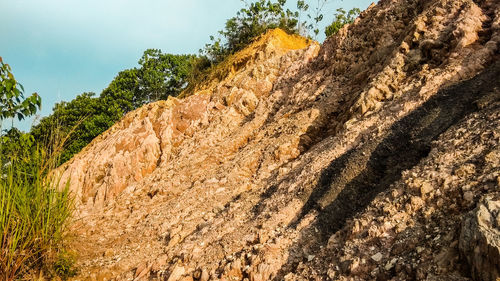 Low angle view of rocks on mountain against sky