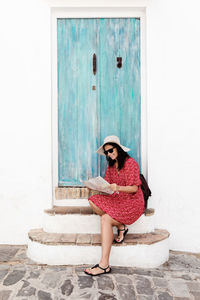 Woman looking away while standing against door