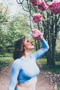 Woman smelling flowers in park