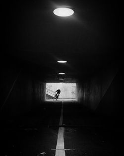 Silhouette person in illuminated tunnel